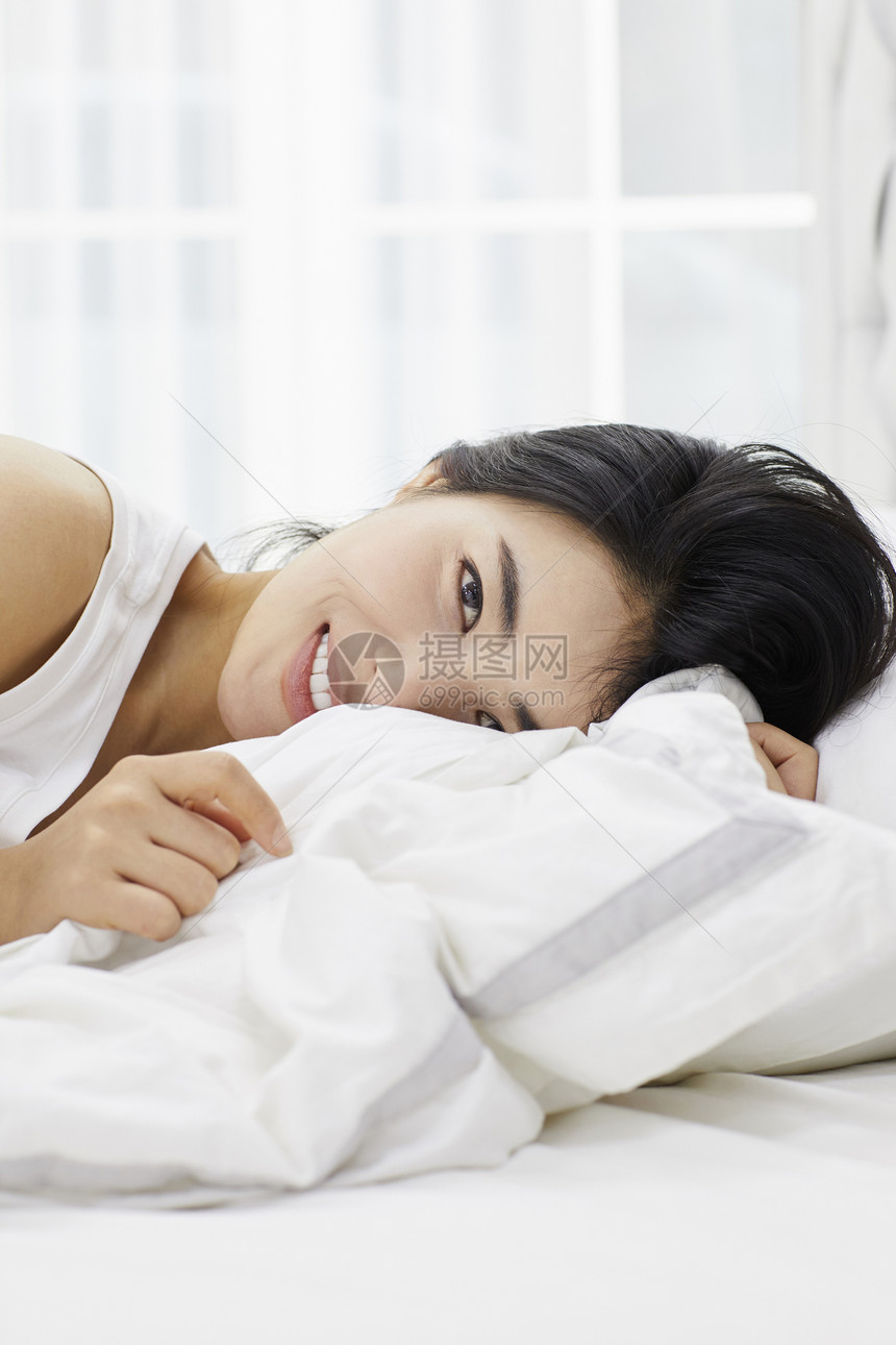 躺在床上的休息的女青年图片