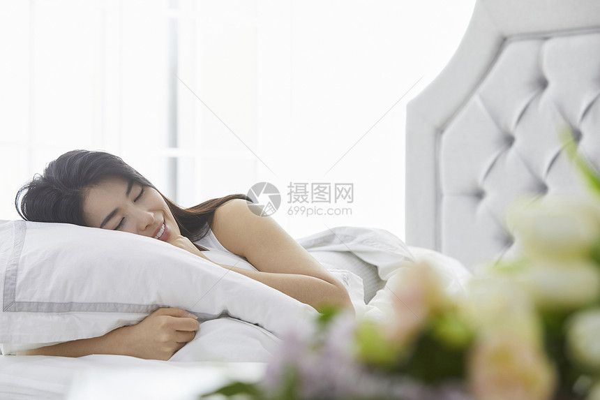 闭眼躺在床上的年轻女子图片