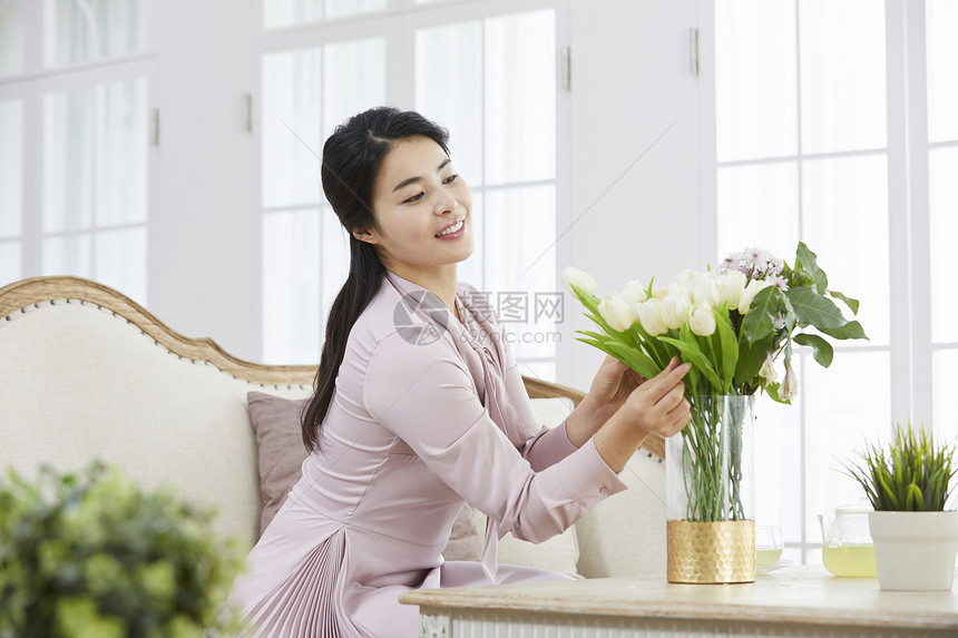 客厅里插花的年轻女子图片