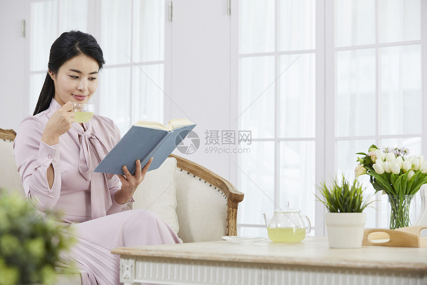 居家阅读喝下午茶的年轻女子图片