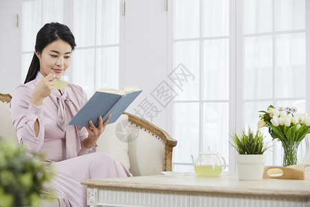 居家阅读喝下午茶的年轻女子图片