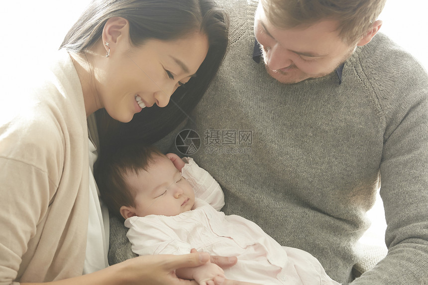 抱着婴儿开心的年轻夫妇图片
