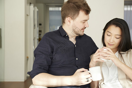 在客厅咖啡休息的夫妇拥抱高清图片素材