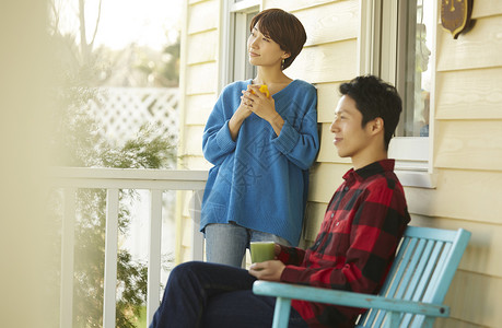 房屋外喝茶的青年夫妻图片