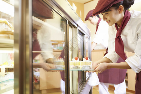 西式甜点商品蛋糕店做兼职工作的妇女在蛋糕商店图片