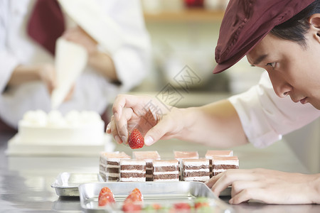 草莓蛋糕店名片西点师专注制作蛋糕背景