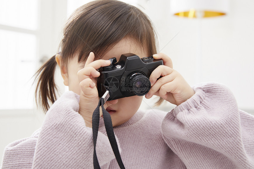 住房生活的女孩用相机拍照图片