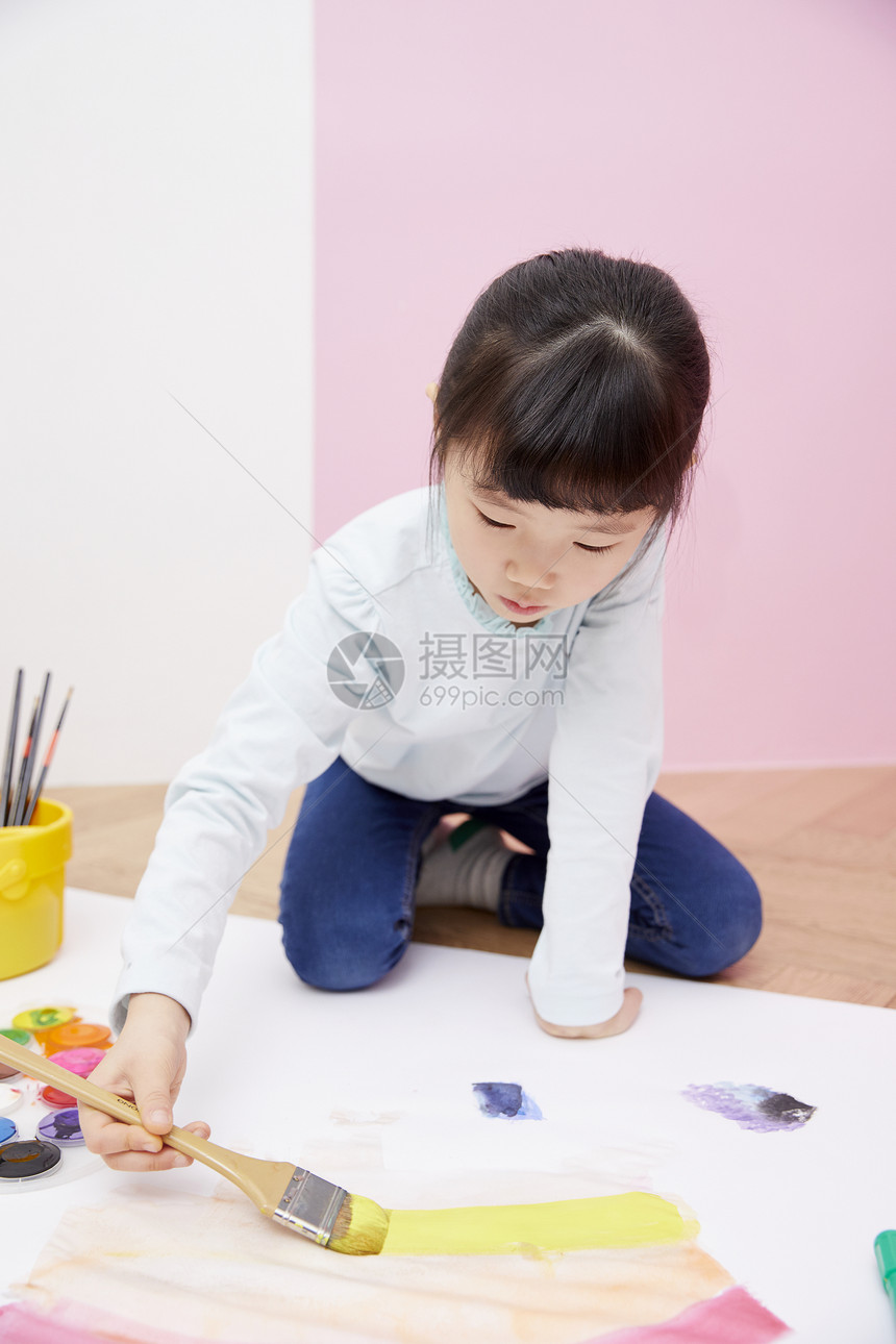 拿着刷子涂鸦的小女孩图片