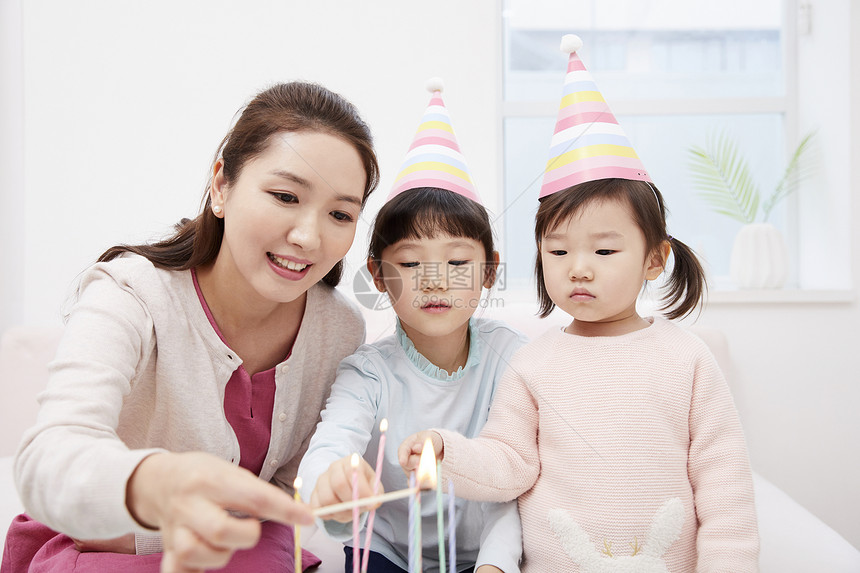 给生日蛋糕点蜡烛的家人图片