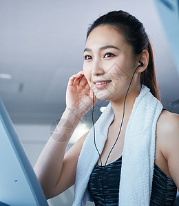 青年女马尾健身房跑步机的女人图片