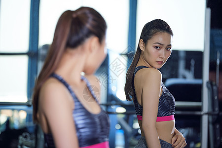 健身馆保养锻炼肌肉检查健身房健身房身体线的妇女背景图片