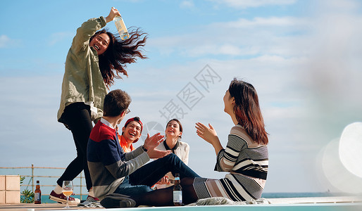 海岸边聚会派对的青年男女喝酒酒精高清图片素材