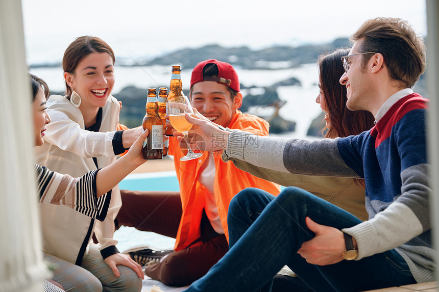 海岸边聚会派对的青年男女喝酒图片