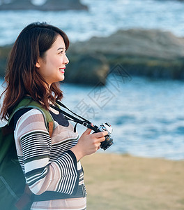 带着相机出去旅游的年轻女性图片