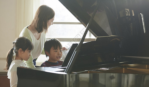 演奏钢琴女孩室内上课音乐室的老师教学生弹钢琴背景
