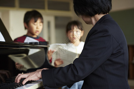 音乐室的老师教学生弹钢琴背景图片