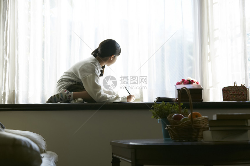 坐在窗台看书学习的小女孩图片