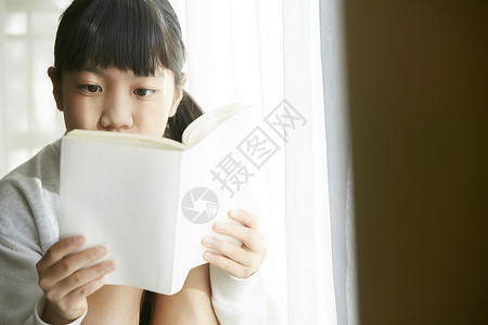 坐在窗台看书的小女孩图片