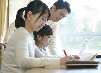 用笔记本电脑的女孩和父母一起学习图片