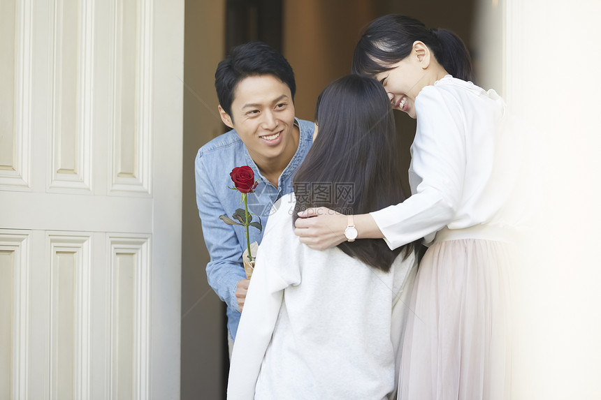 爸爸拿着一只花送给母亲和女儿图片