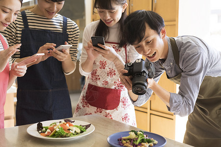 户内厨房拍摄食物的男女图片