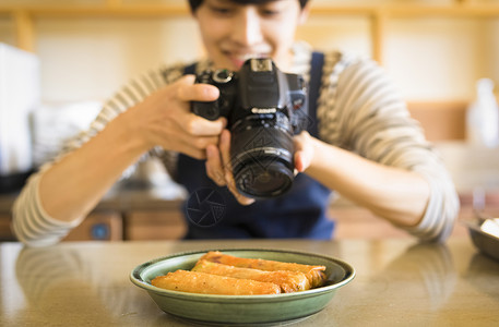 男子用相机拍照食物图片