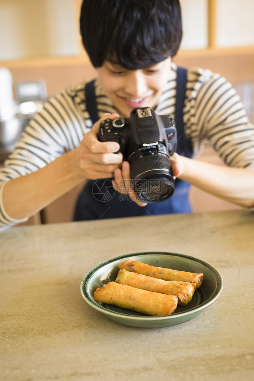 给美食拍照的年轻人图片