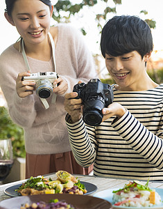 年轻男女拍摄美食图片