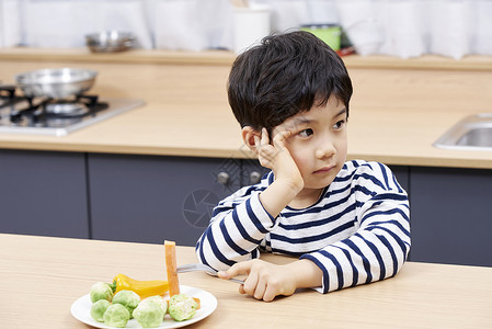 拿着叉子吃胡萝卜的小男孩图片