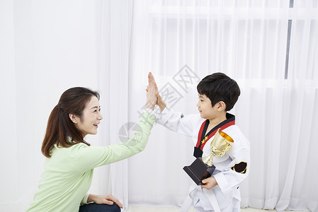 妈妈和练习跆拳道儿子击掌背景图片