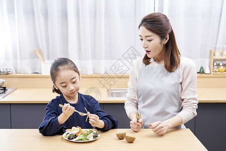 厨房吃健康食物的母女图片