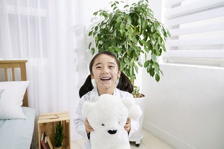 小女孩抱着玩具熊开心笑图片