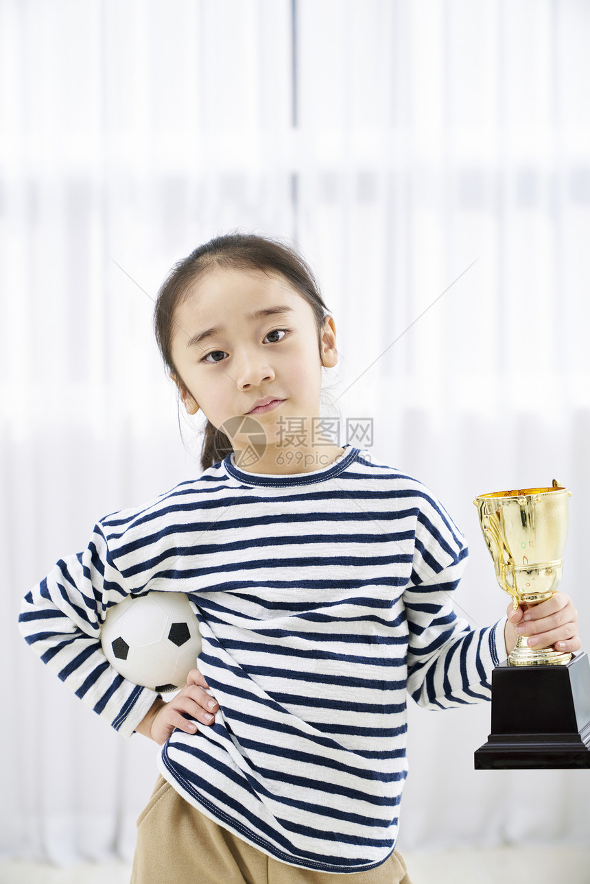 小女孩抱着奖杯图片