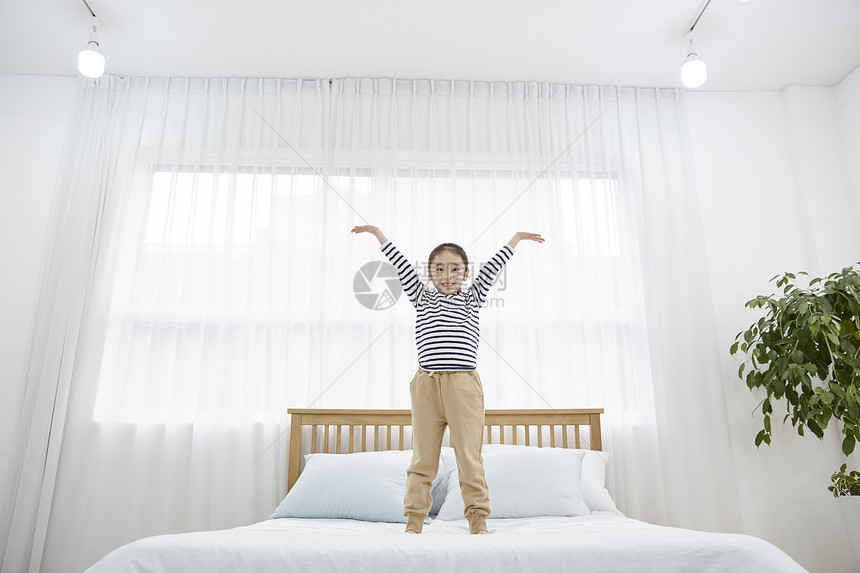 房子卧室床上开心的孩子图片