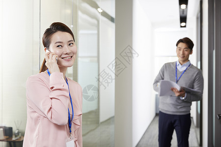 企业男职员看着女职员打电话图片