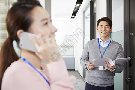 企业男职员看着女职员打电话图片