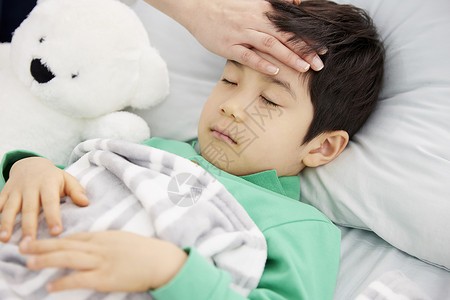 妈妈照顾生病在床的男孩图片