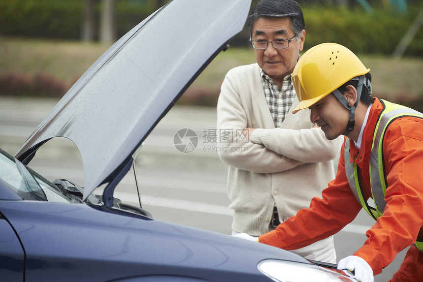 看着汽车故障的老年男性图片