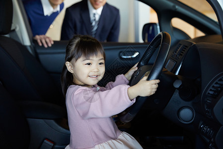 人类女孩们驾驶员座椅来到商店的汽车经销商驾驶员座位上的女孩图片