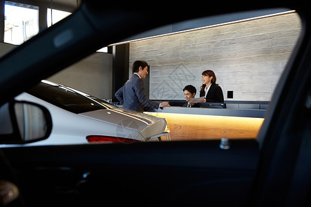 客户服务出售促销员工和客户在汽车经销商柜台讲话背景图片