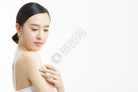 肌体乳霜手臂涂抹身体乳的年轻女子背景