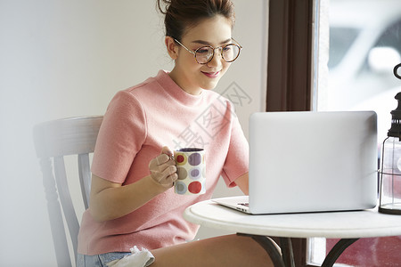咖啡馆使用笔记本电脑的年轻女性图片