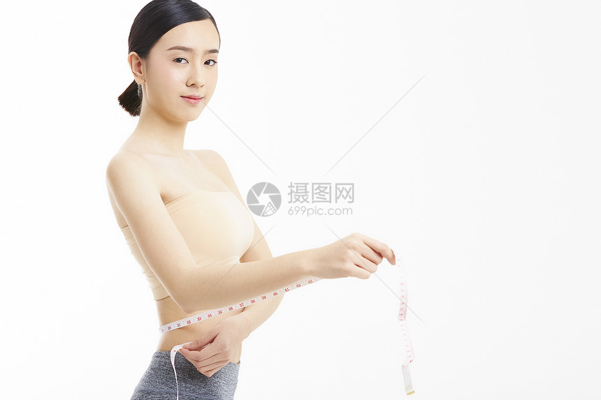卷尺测量腰围的女性特写图片