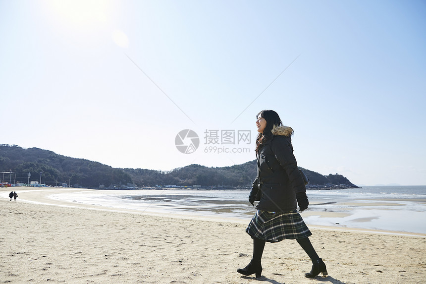 海滩边散步的女青年图片