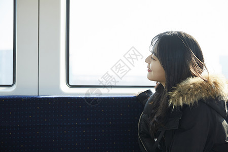 坐在地铁上看向窗外微笑的少女图片