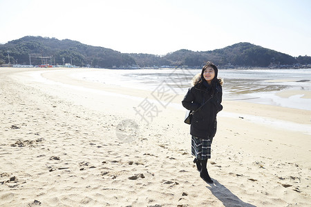 海滩上散步的年轻女子图片