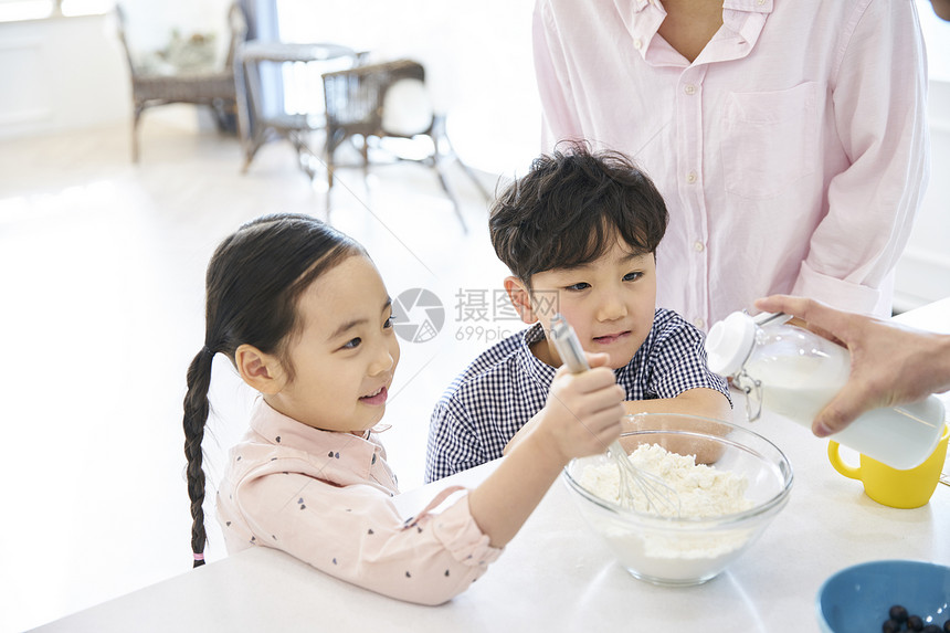 在家庭厨房里做饭的一家人图片