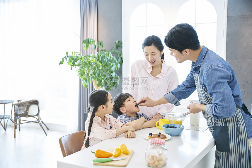 在家庭厨房里做饭的一家人图片