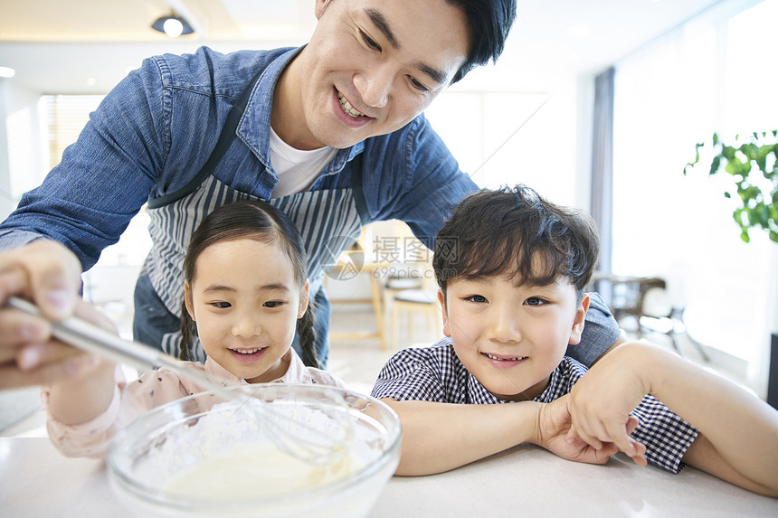 在家庭厨房里做饭的一家人图片