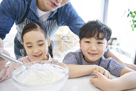 在家庭厨房里做饭的一家人图片